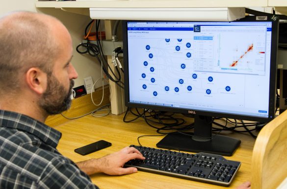 Scientist monitoring data on a computer screen.